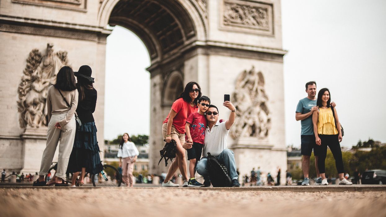 Family taking a picture in front of the Arc de Triomphe