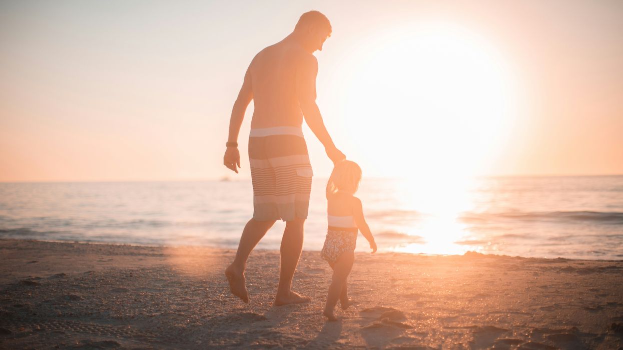 Father and kid at a beach at sunset