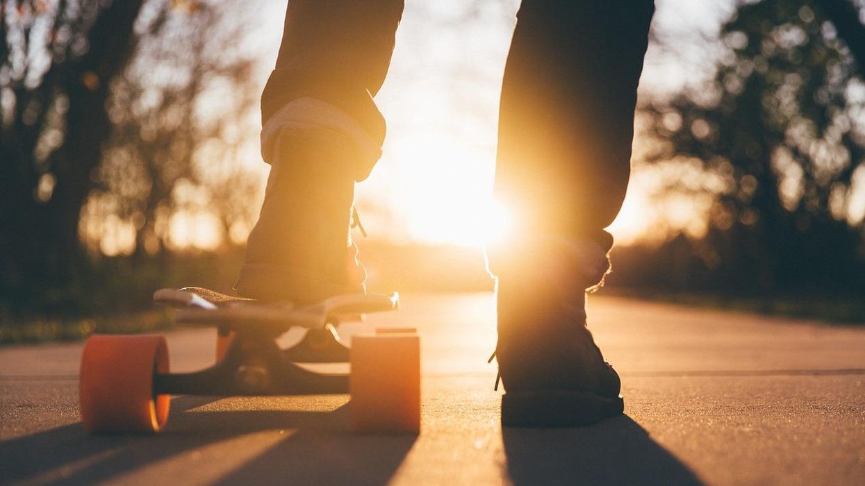 feet in sneakers and a skateboard