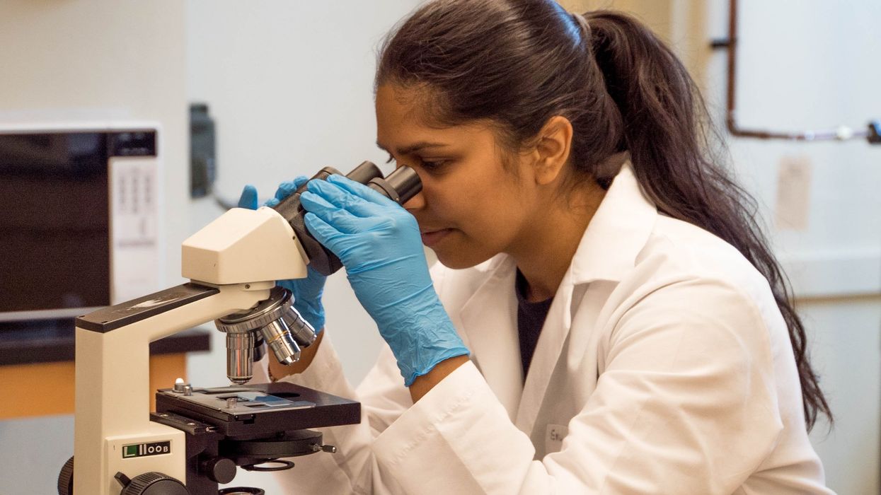 Female scientist peering into a microscope
