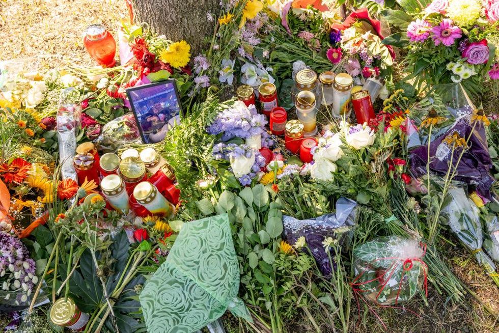 flowers, candles and pictures by a tree near where Khadidja's body was discovered in the car on Aug. 17, 2022.