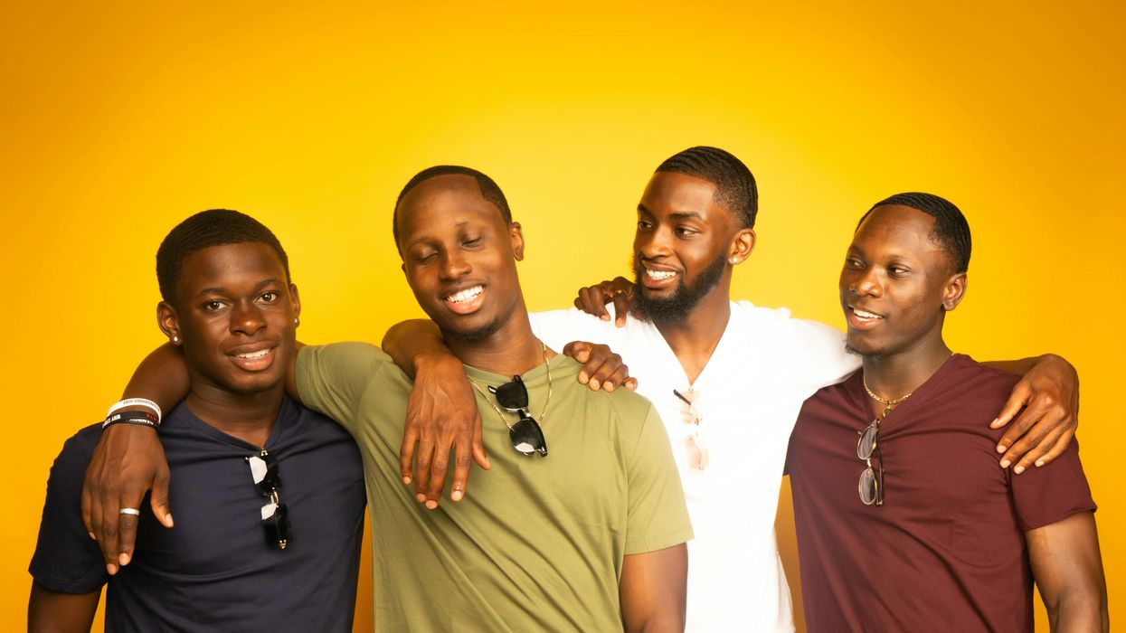 Four friends standing together, two looking at one in surprise