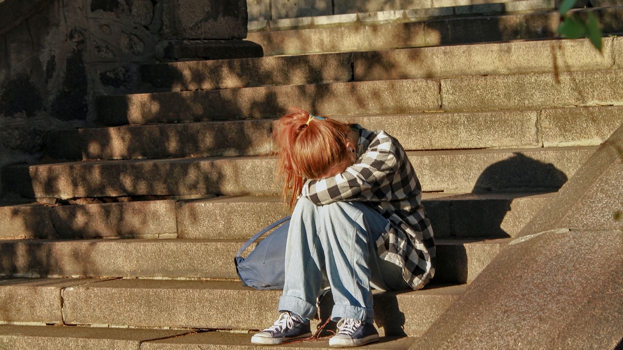 Girl crying on school stairs.