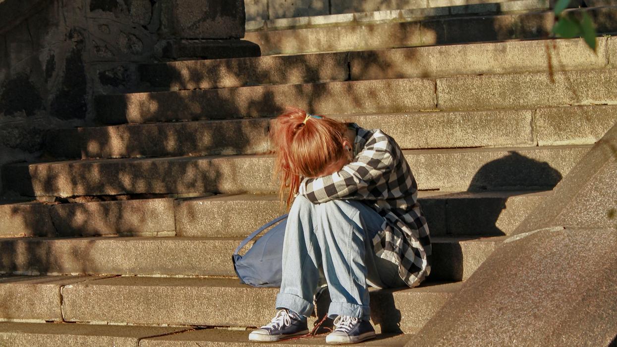 Girl crying on school stairs.