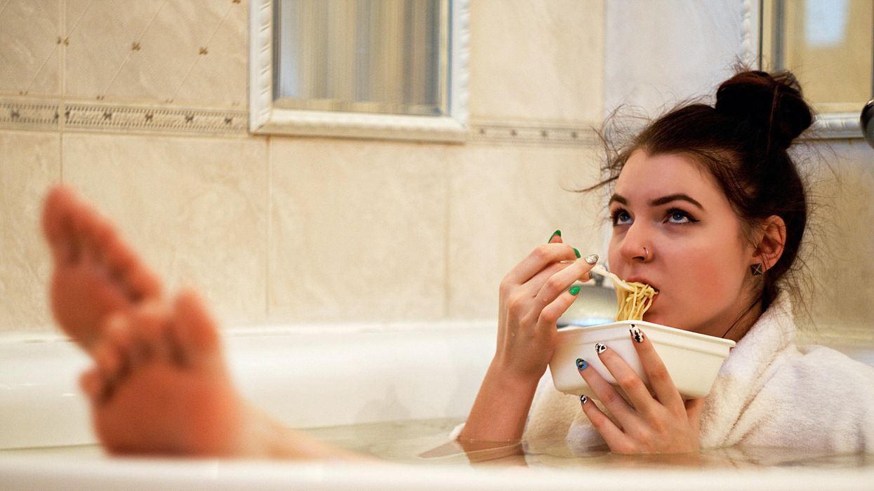 girl in bathtub holding white ceramic mug