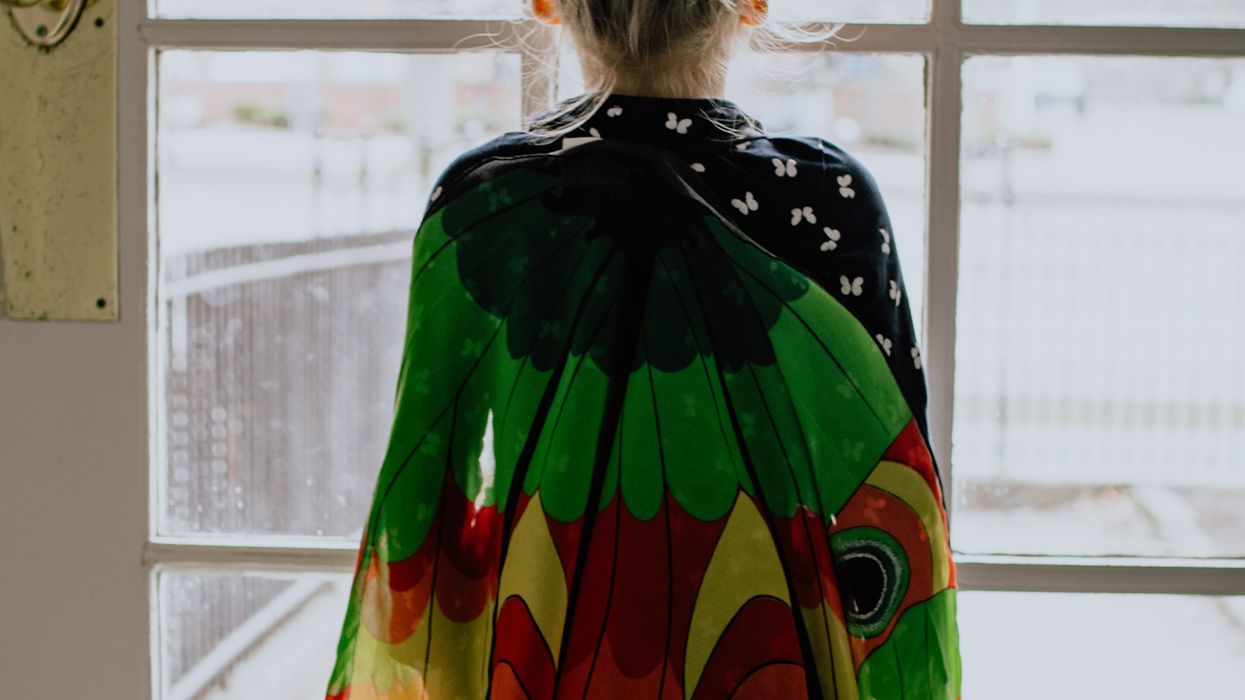 girl in butterfly wings standing in front of door