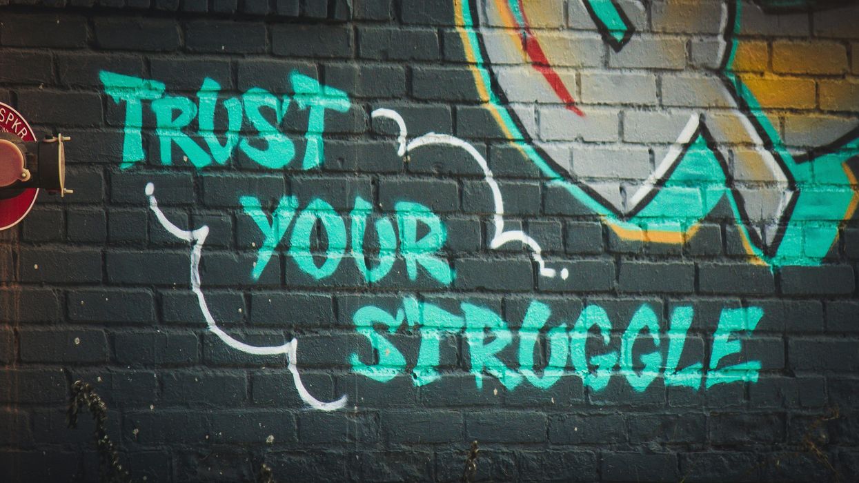 green 'trust your struggle' graffiti
