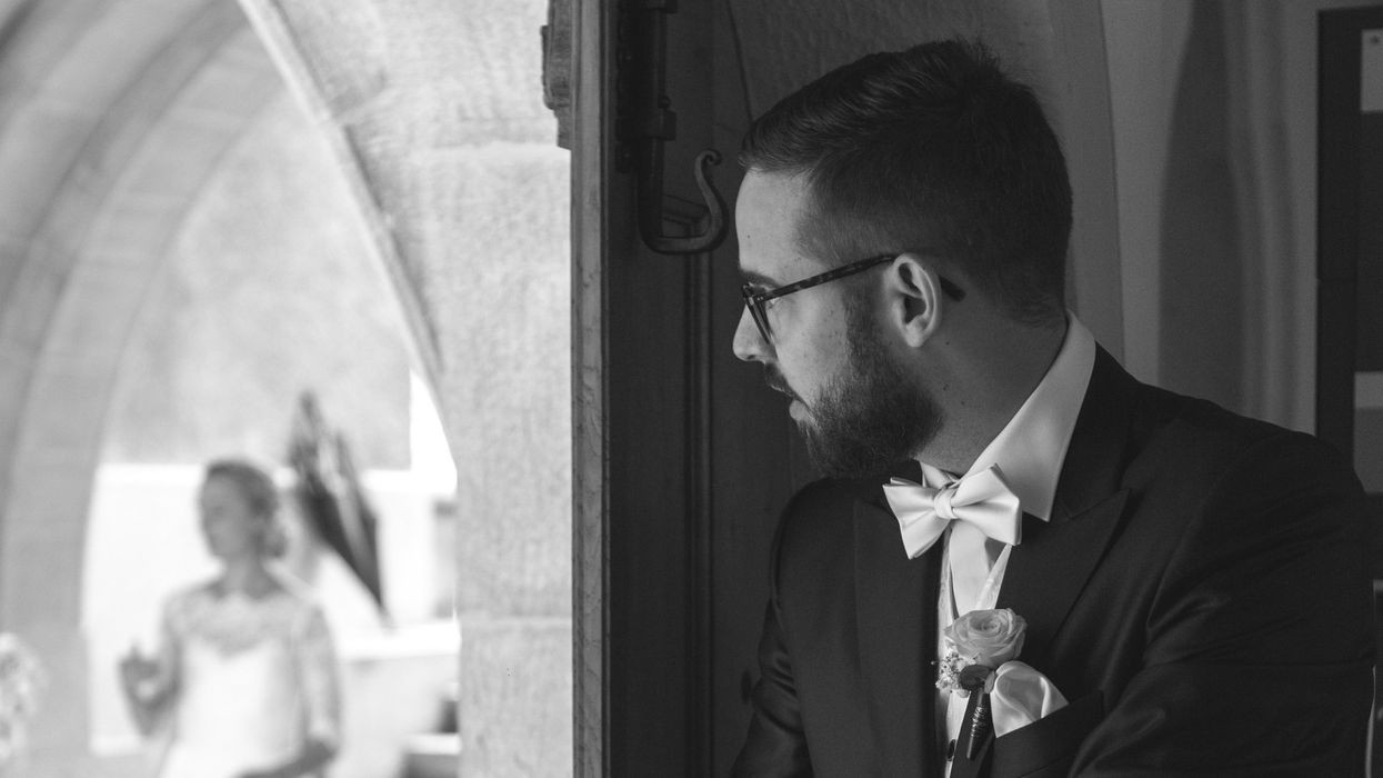 Groom observing bride from another room