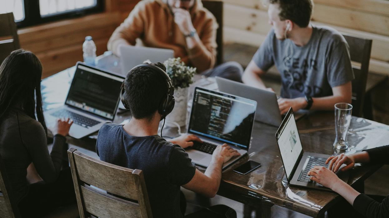group of people using laptop computers in an office