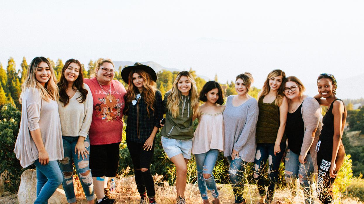 group of women standing on rock hilltop