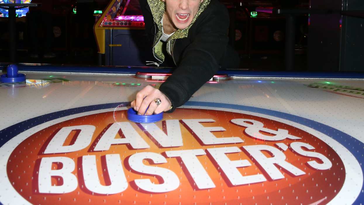 Guy playing air hockey at a Dave & Busters