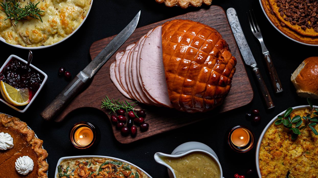 Ham, Pie, casserole and gravy on a dinner table.