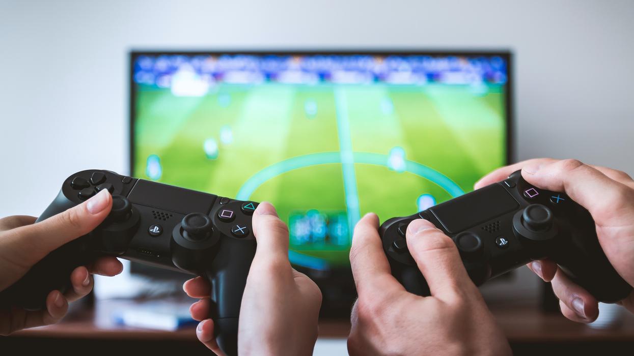 Hands of two gamers holding gamepads