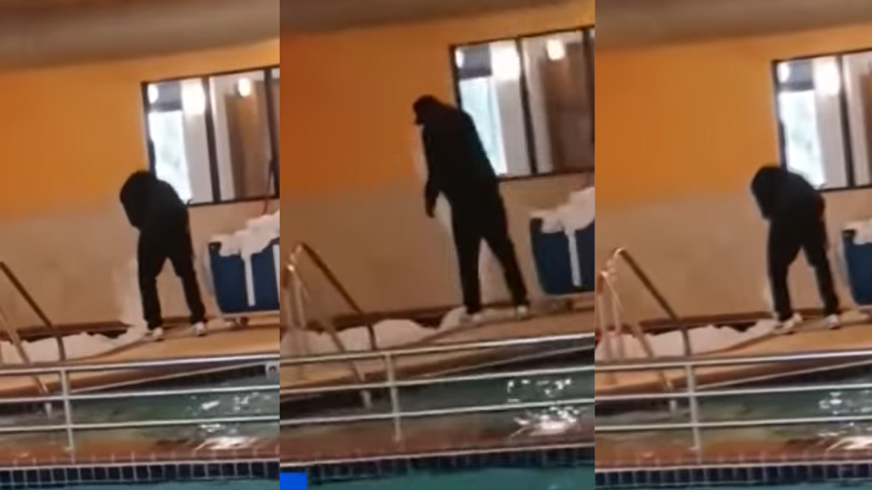 Hotel worker washing bed sheets in hot tub