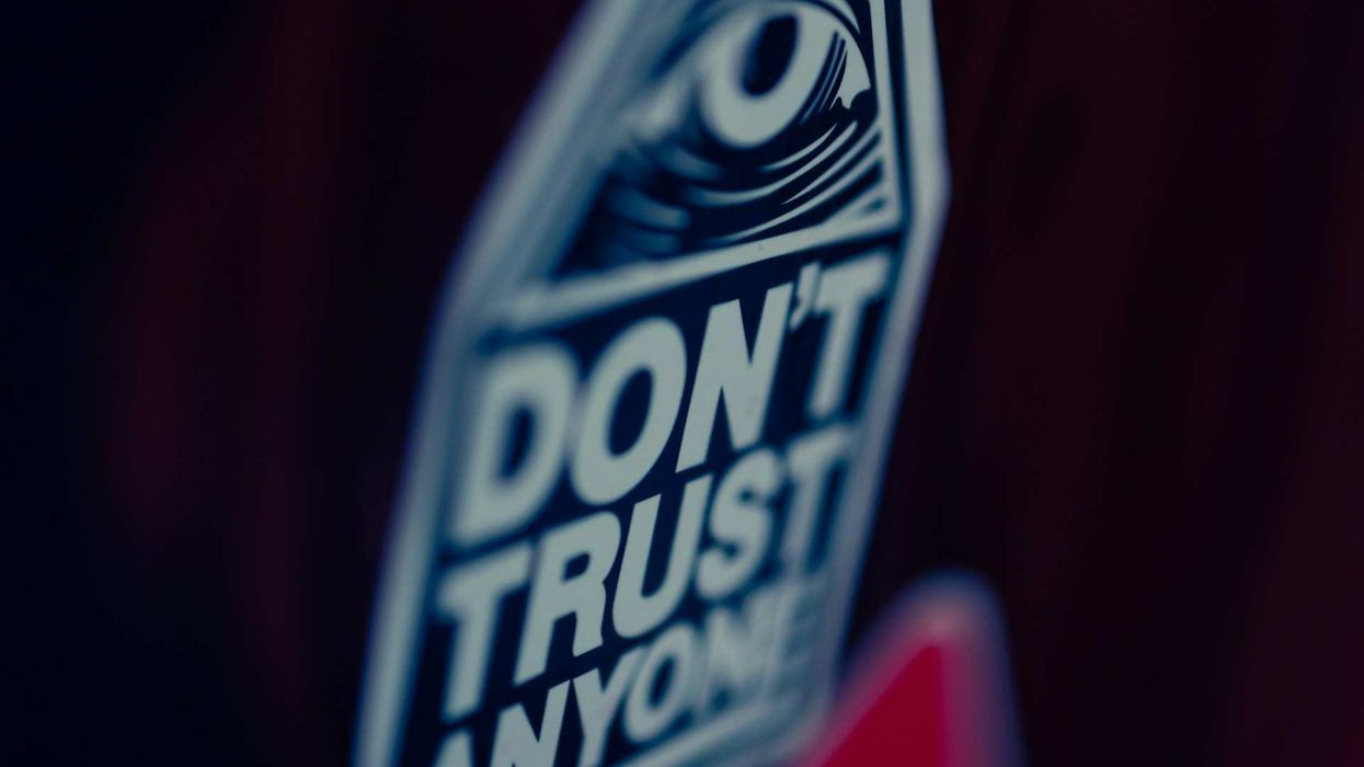 Image of close-up, blurry shot of a sign that says... "Don't Trust Anyone."