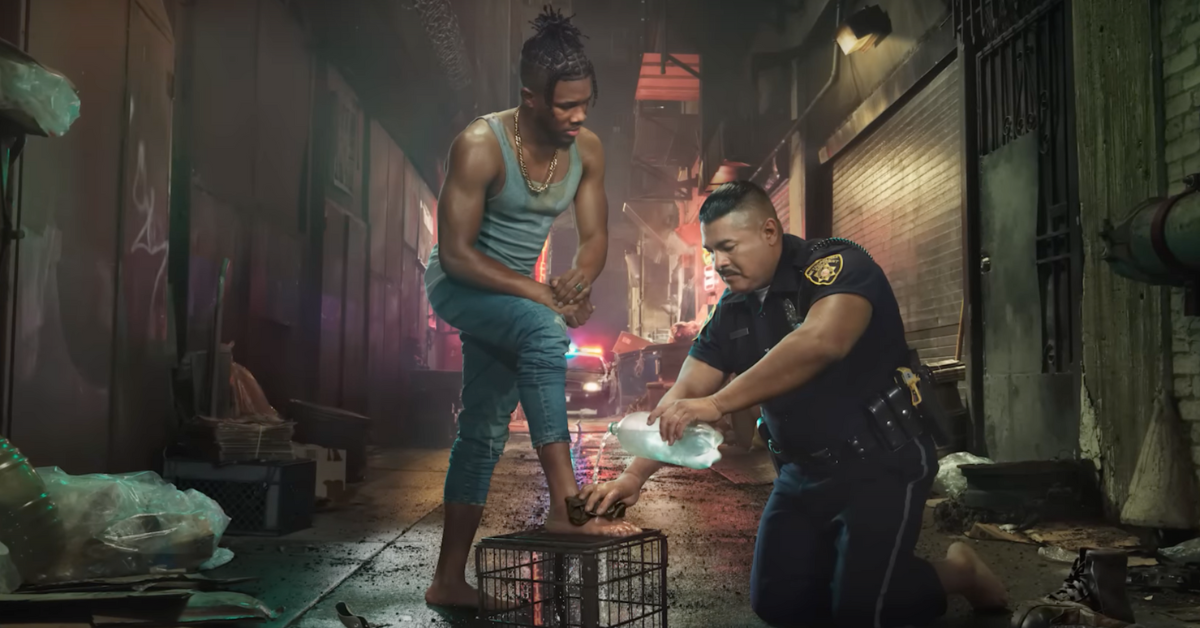 Image of police officer washing Black man's feet from He Gets Us campaign