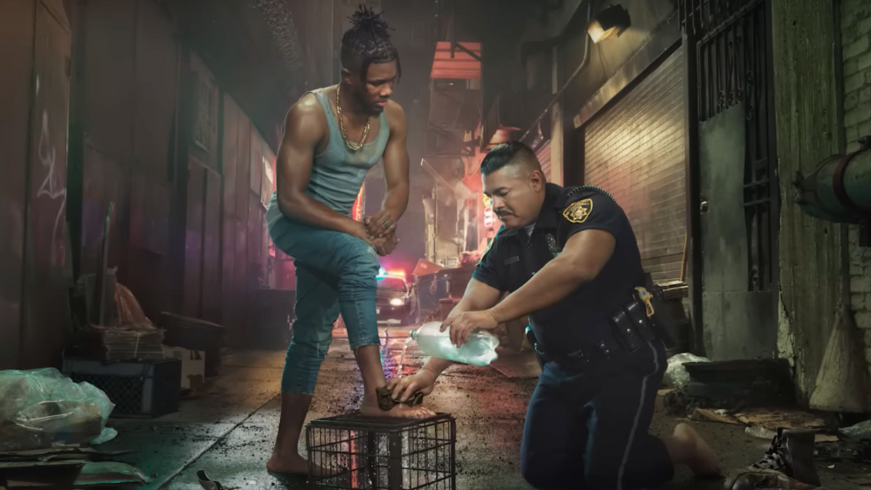 Image of police officer washing Black man's feet from He Gets Us campaign