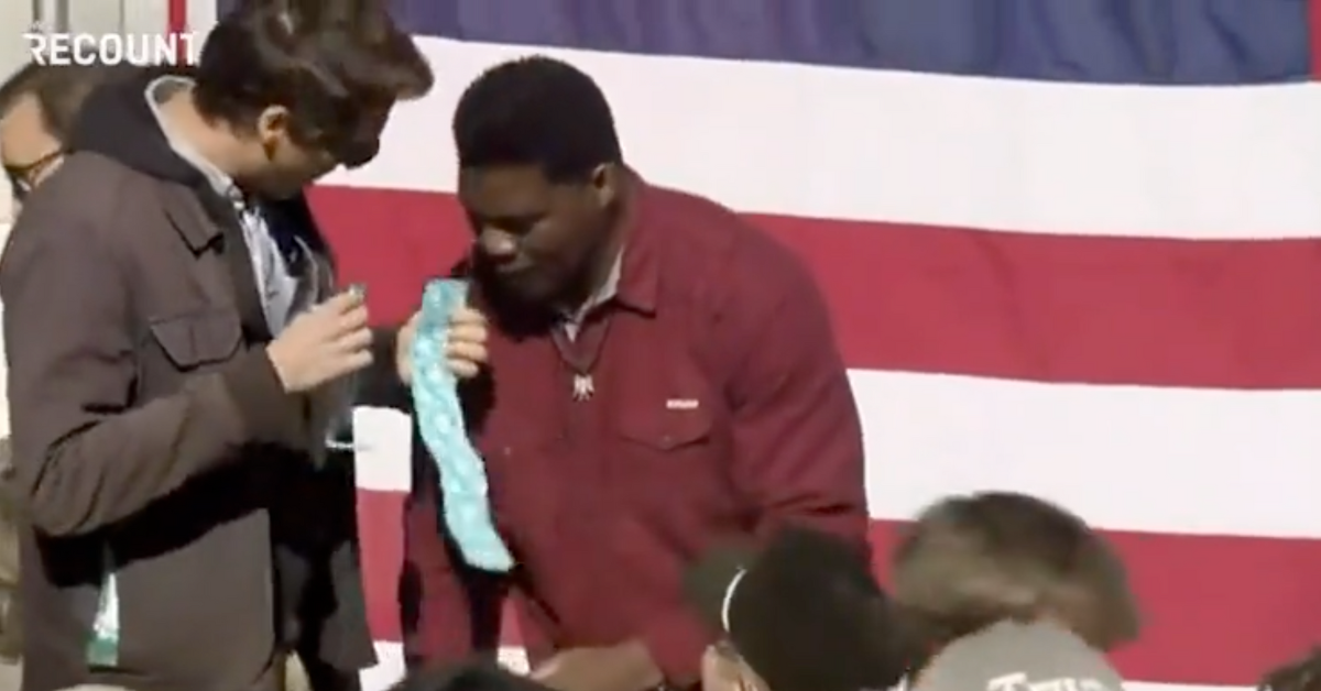 Prankster Comedian Interrupts Herschel Walker Campaign Event To Hand Him Condoms In Viral Video