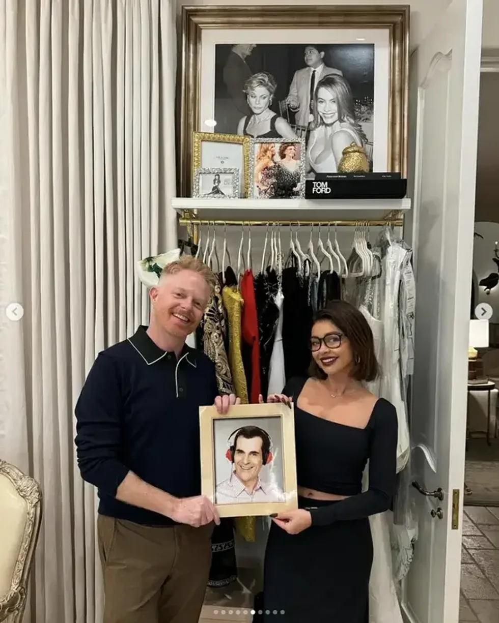 Instagram screenshot of Jesse Tyler Ferguson and Sarah Hyland holding Ty Burrell photo