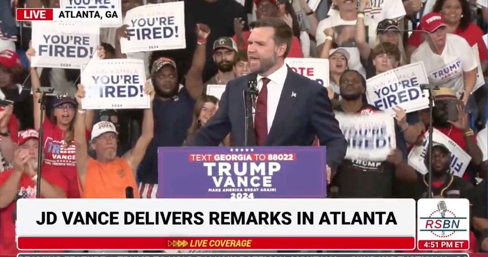 J.D. Vance speaks as MAGA attendees hold "You're Fired" signs behind him