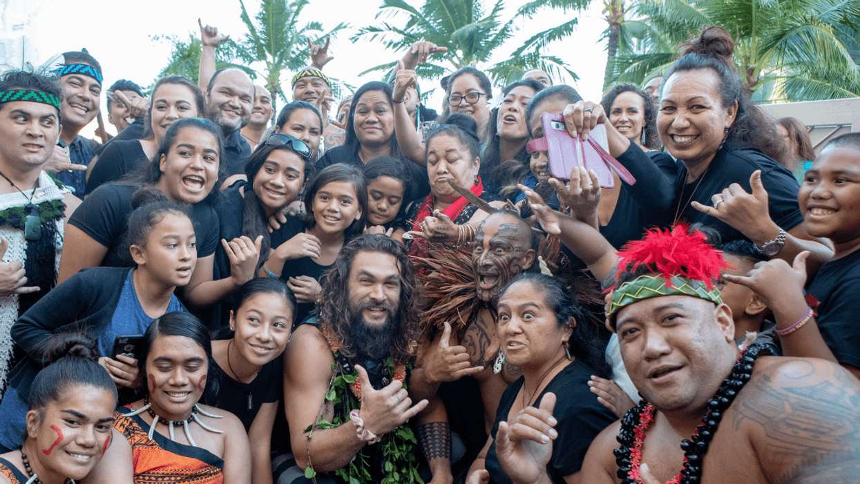 Jason Momoa (center) poses for a photo with fans in Honolulu, Hawaii.
