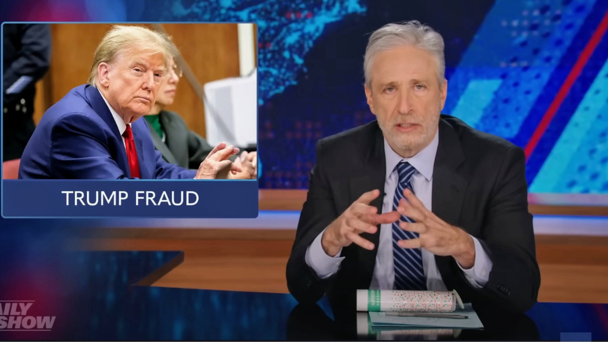 Jon Stewart with a photo of Donald Trump inset