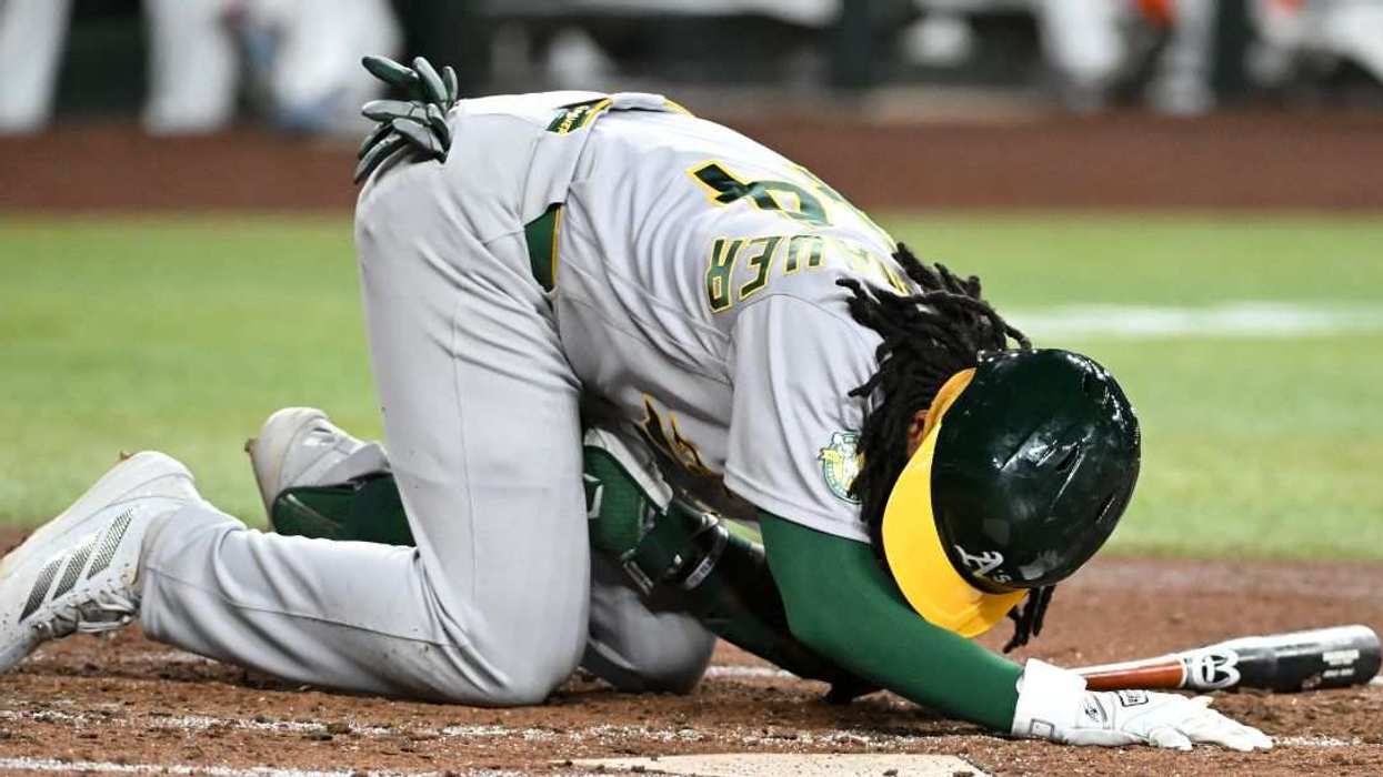 Joshua Kuroda-Grauer #44 of the Athletics lies in the batter's box after getting hit by a foul ball.