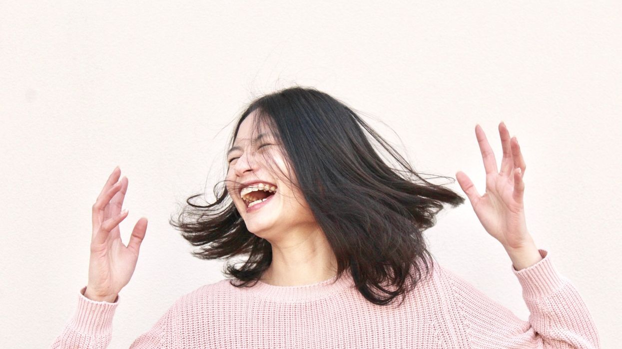 laughing woman wearing pink sweater