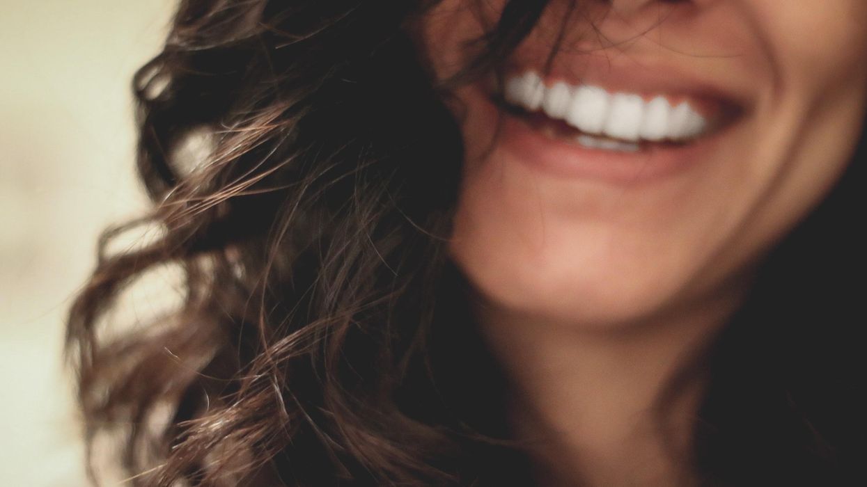 long dark haired woman smiling close-up photography