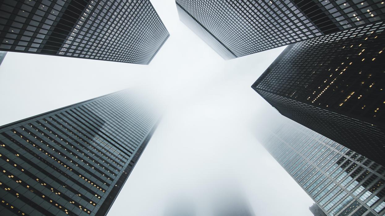 Low angle photo of foggy skyscrapers