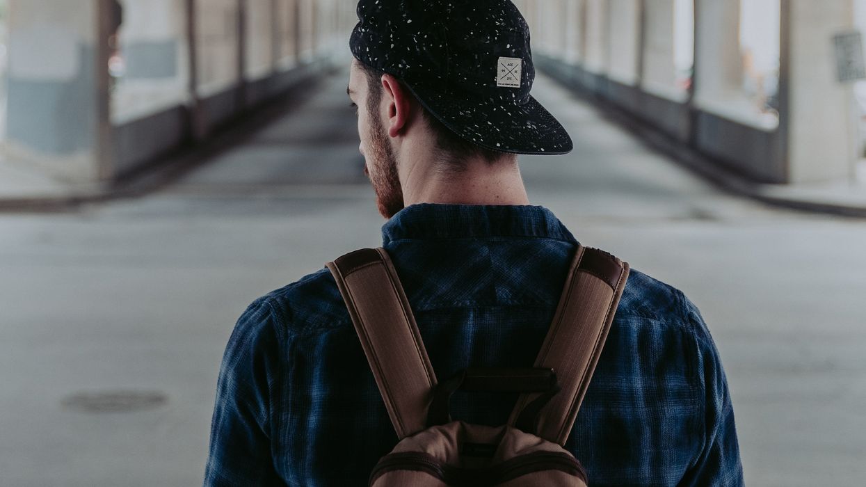 Man alone with a backpack under a bridge