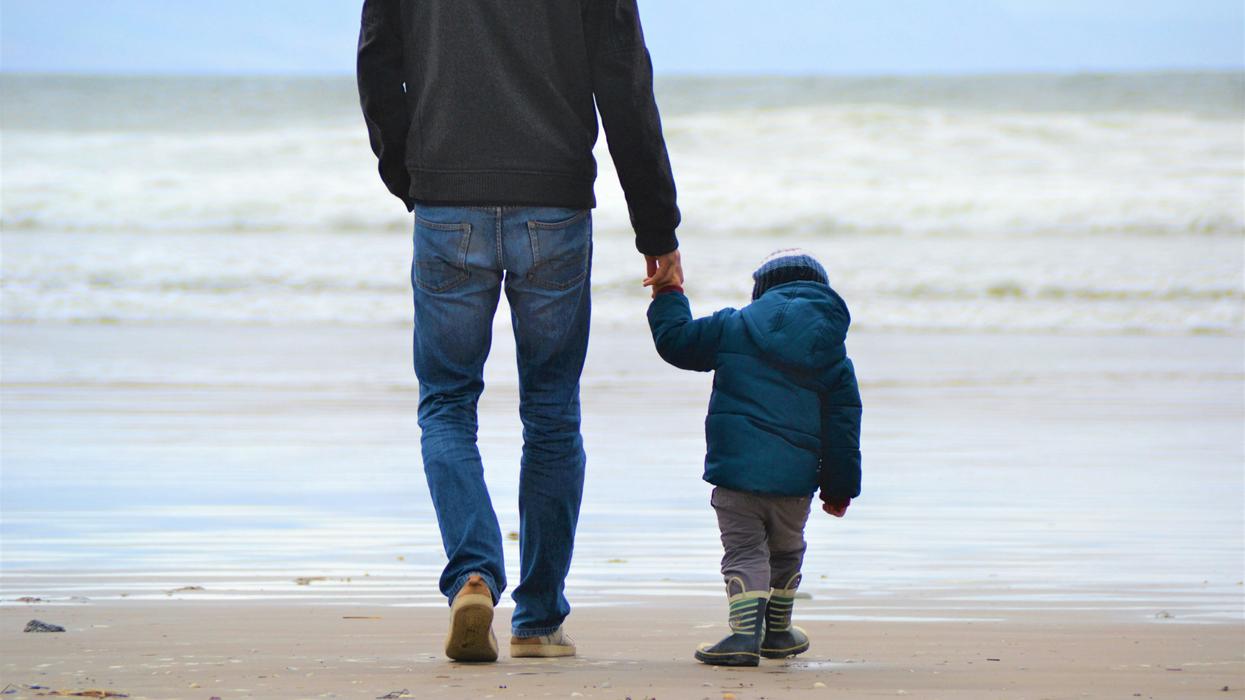 man and boy walking on seashore