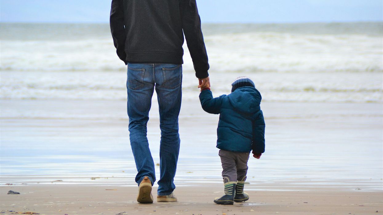 man and boy walking on seashore