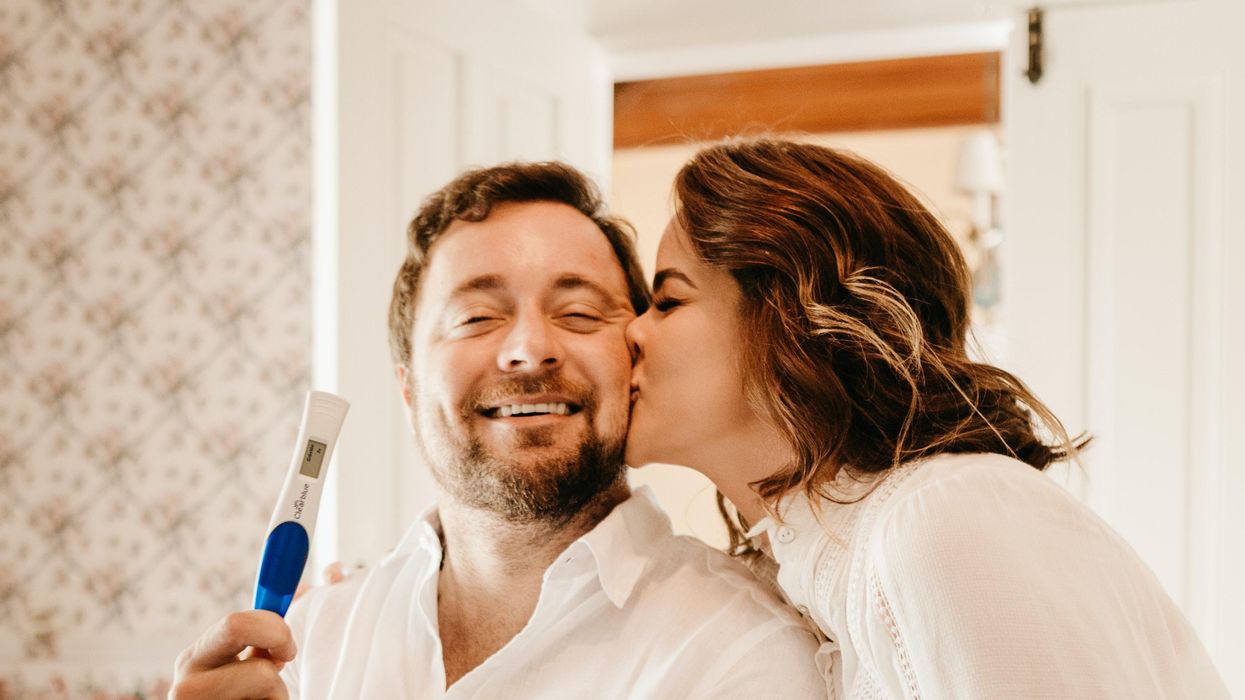 Man and woman holding positive pregnancy test