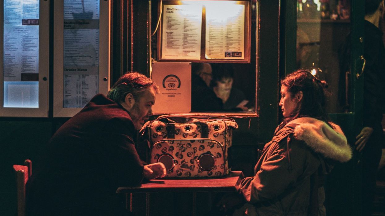 man and woman sitting in front of each other at night