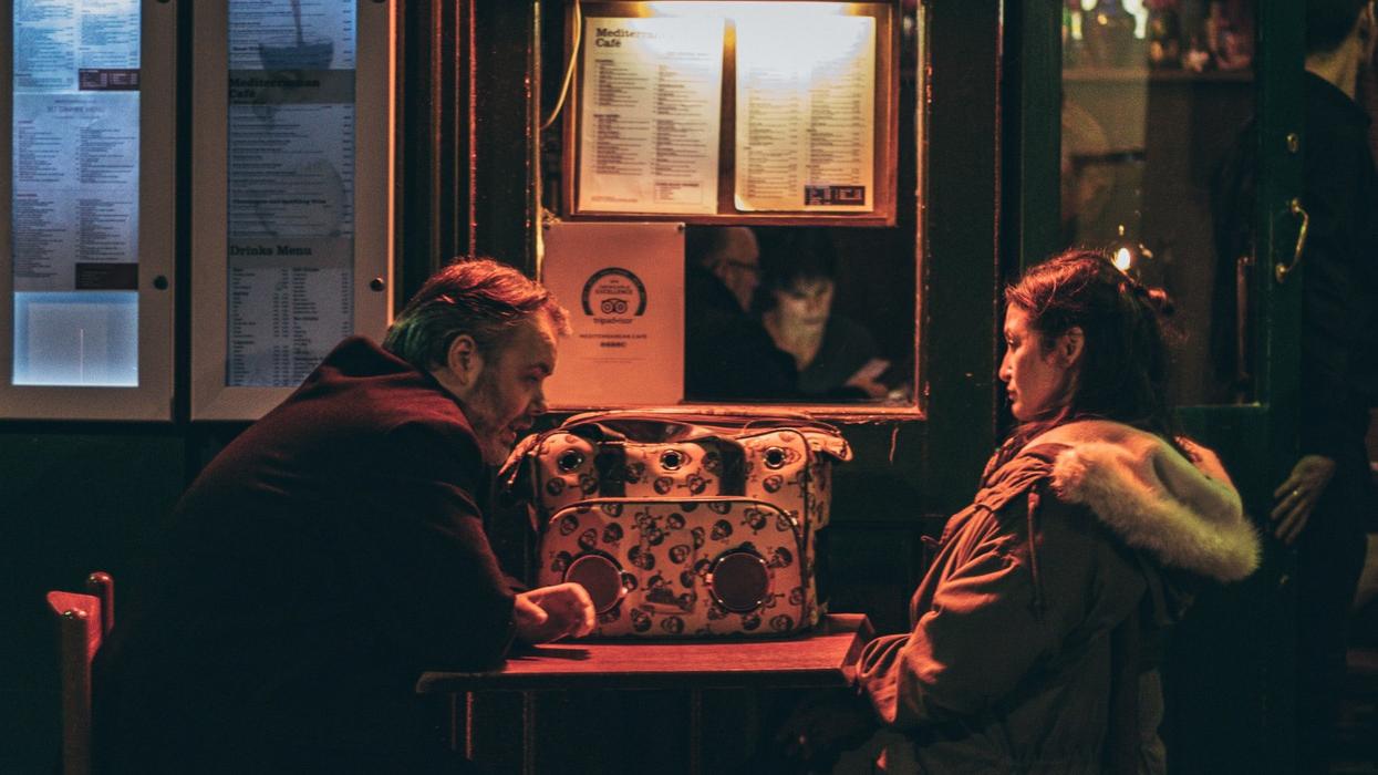 man and woman sitting in front of each other at night