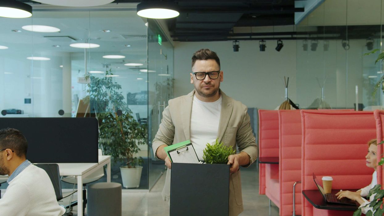 Man carrying a box of belongings out of the office
