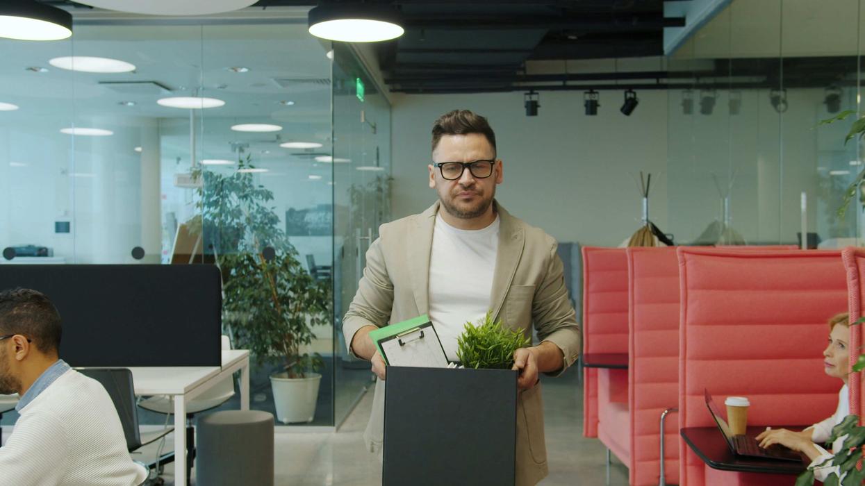 Man carrying a box of belongings out of the office