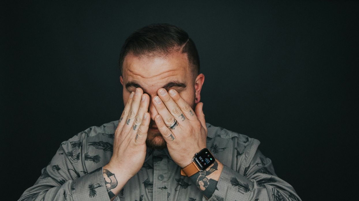 man covering his eyes