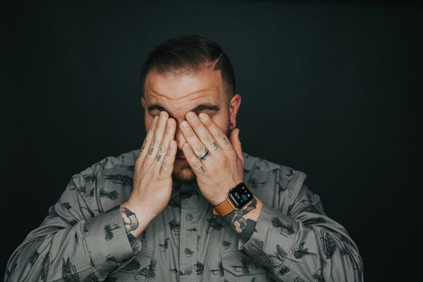 man covering his eyes