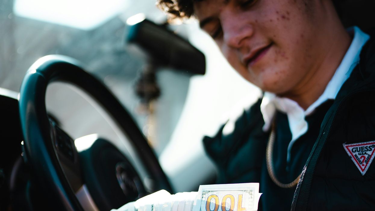 Man fanning out a wad of U.S. bills