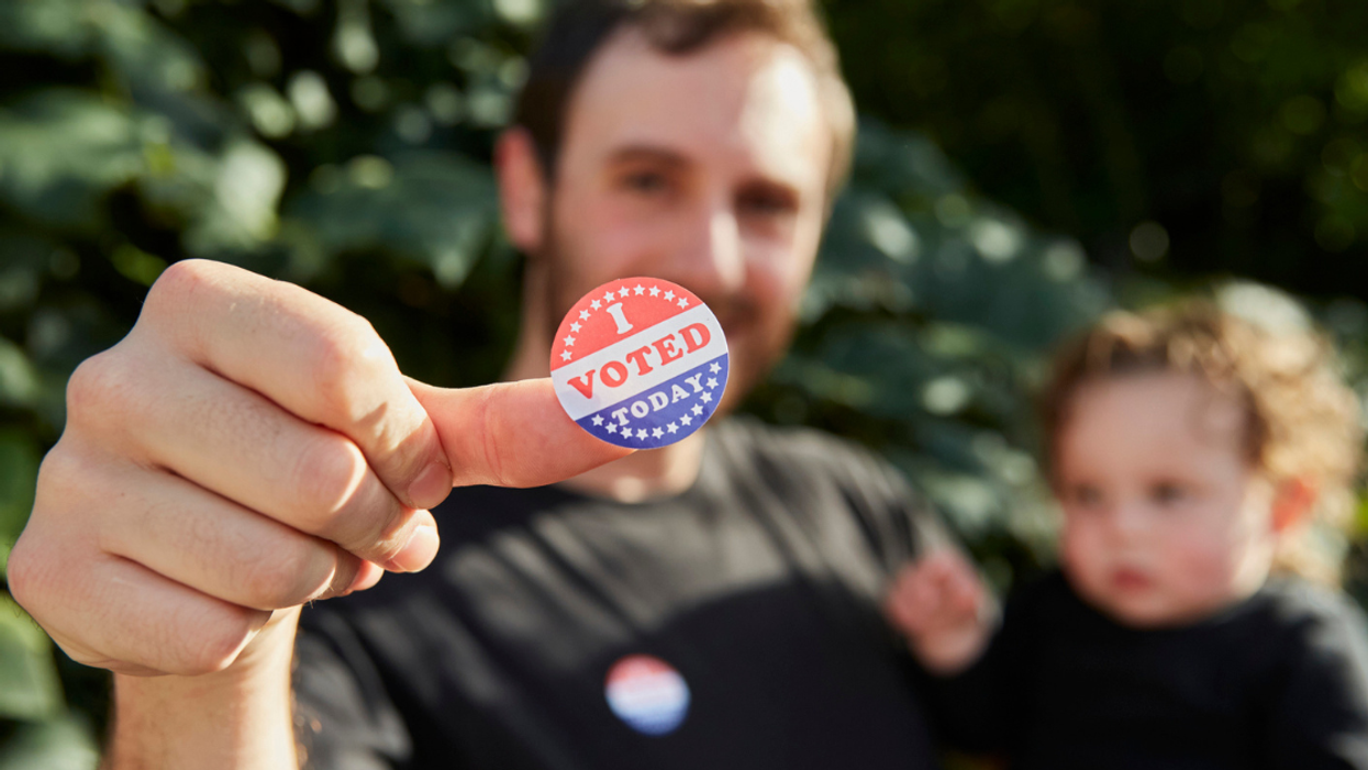 man holding child with I Voted sticker