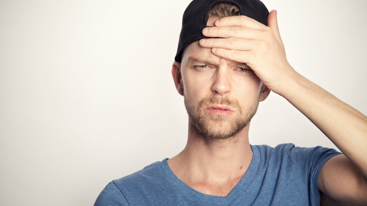 Man holding his hand to his forehead, appearing overwhelmed