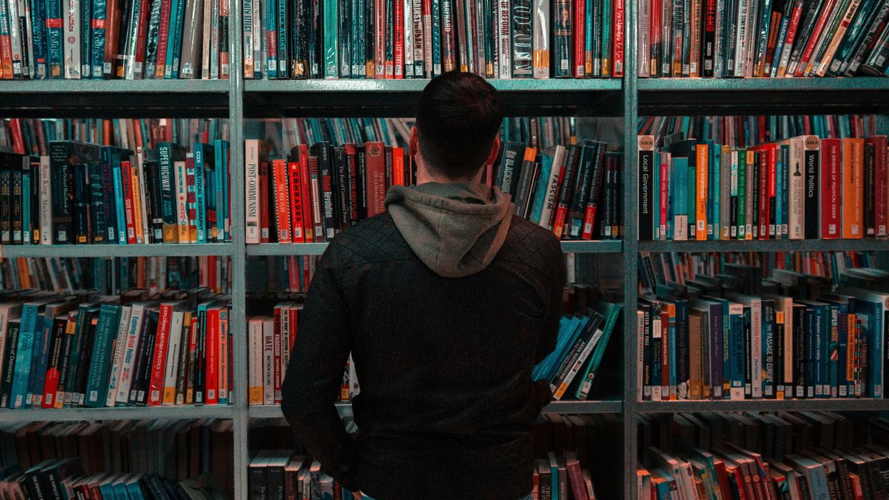 Man in an aisle of books at a library