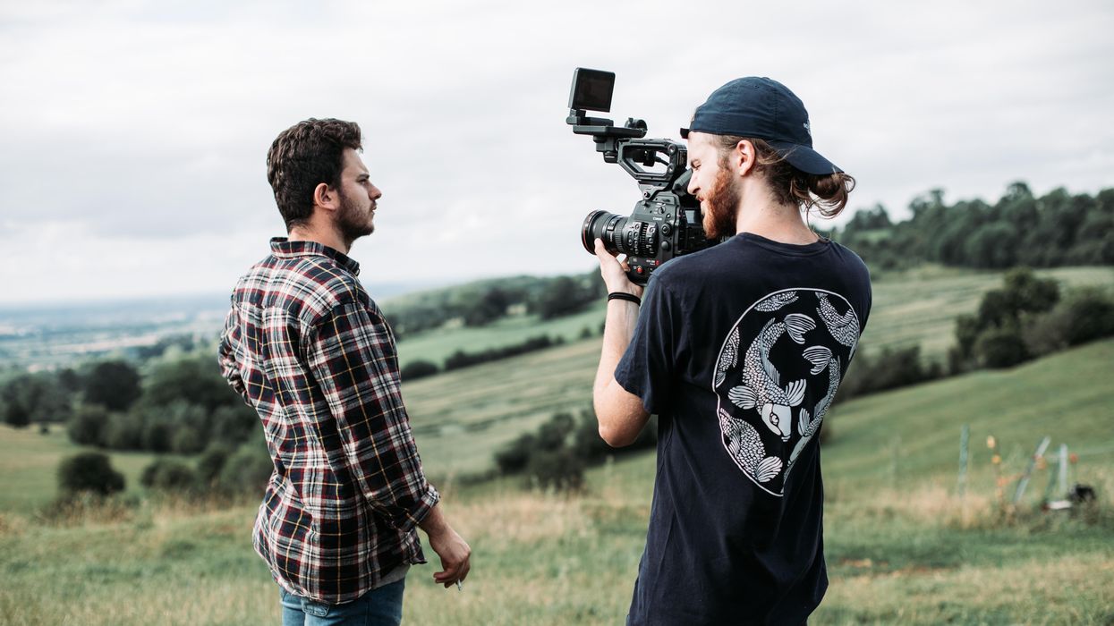 man in black and white crew neck t-shirt holding black video camera