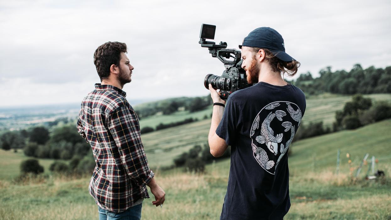 man in black and white crew neck t-shirt holding black video camera