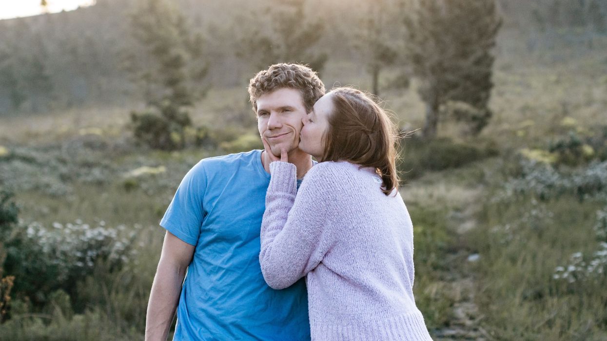 man in blue crew neck t-shirt hugging woman in white long sleeve shirt