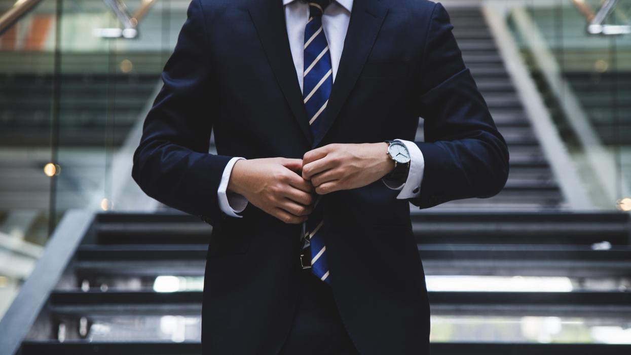 man in business suit standing near the stairs