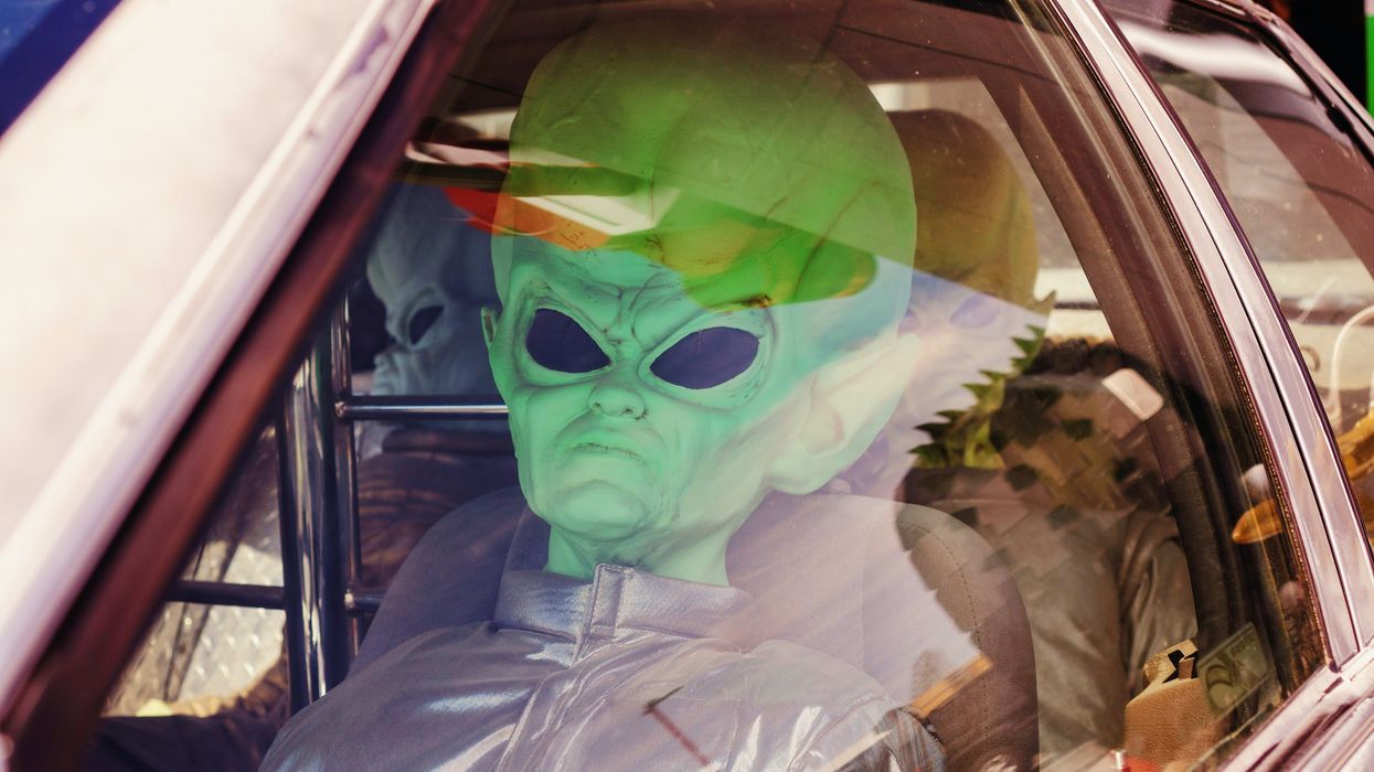 man in green mask inside car