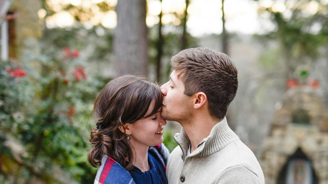 Man kissing woman on her forehead